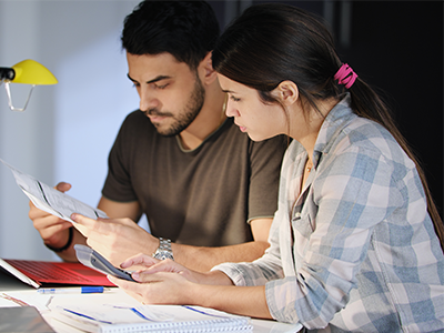 Man and woman sitting side by side reviewing bills