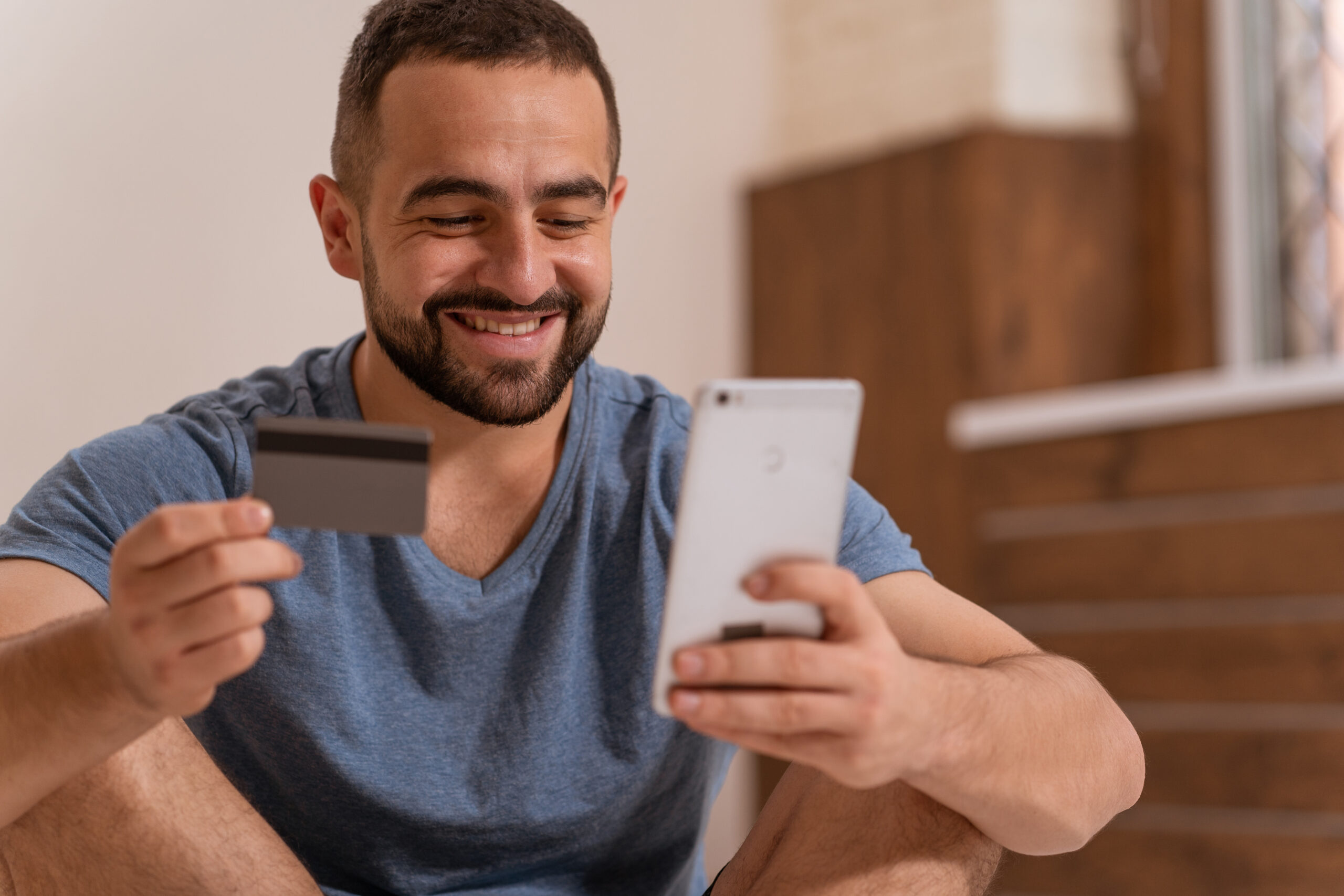 Man looking at his card and phone